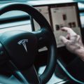 נהג מפעיל את מסך המגע במכונית Tesla