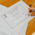יד חותמת על מסמך תעודה – המחשה לאימות והרשאות הנפקת תעודות