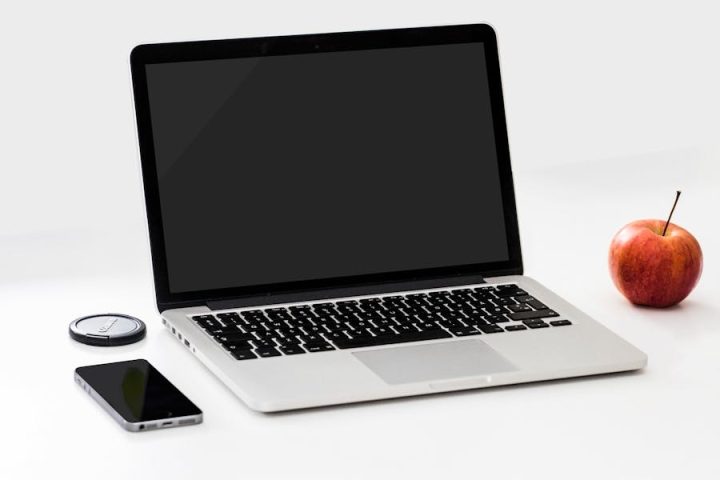 מחשב MacBook וסמארטפון על שולחן עבודה