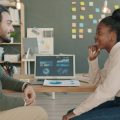 שני אנשי מקצוע מנתחים נתונים במשרד, המחשה ל-OAuth ב-AWS Glue Data Catalog